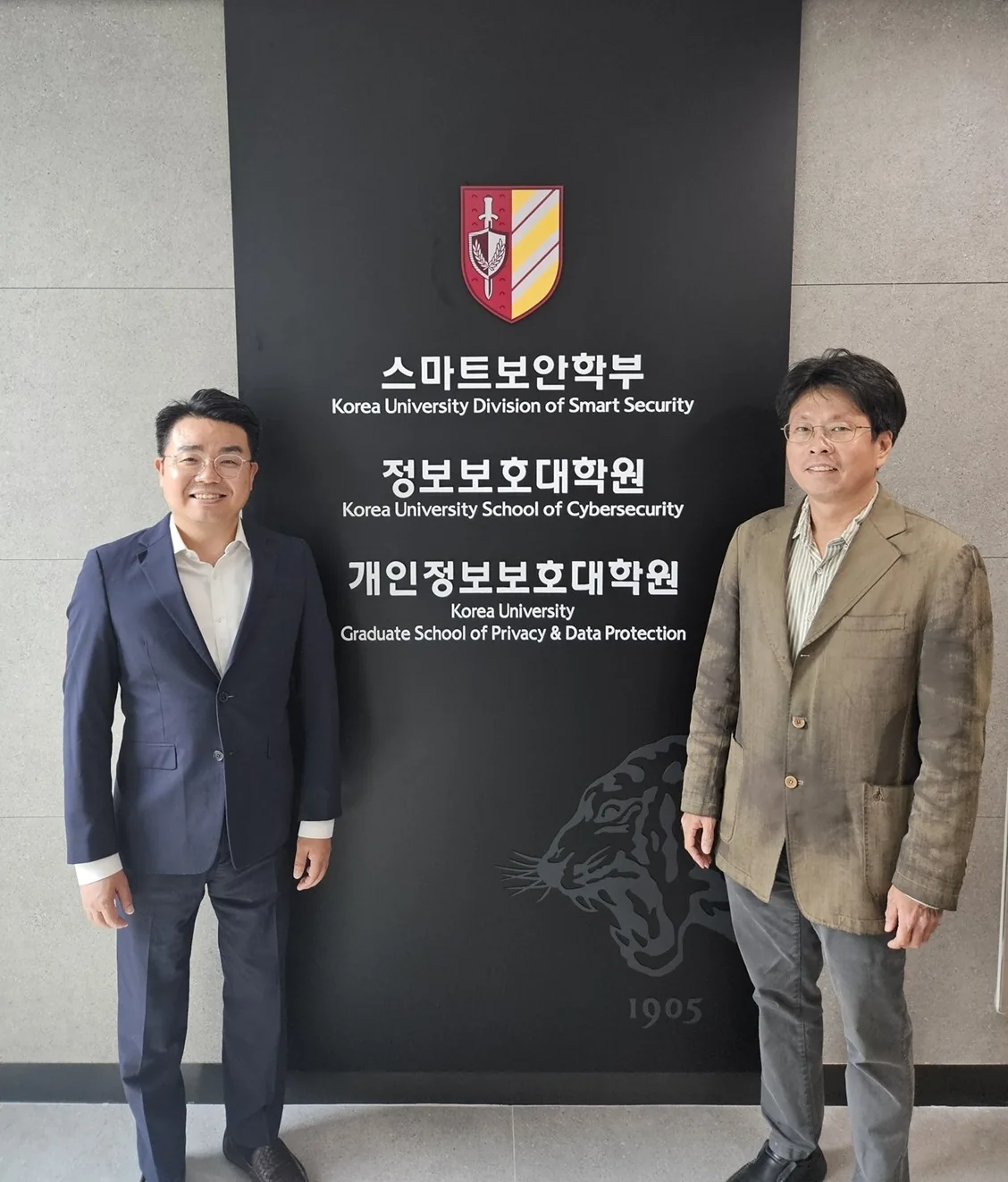 고려대학교 정보보호대학원 안내판 앞에 선 공동창업자 심준식(왼쪽)과 이중희.